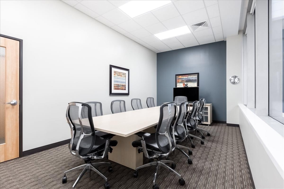 Large conference room at 1000 Lafayette Blvd. featuring a long table and mesh chairs against a blue wall.
