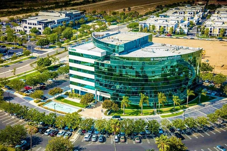 High-angle aerial shot of the signature curved glass building and surrounding parking lot.