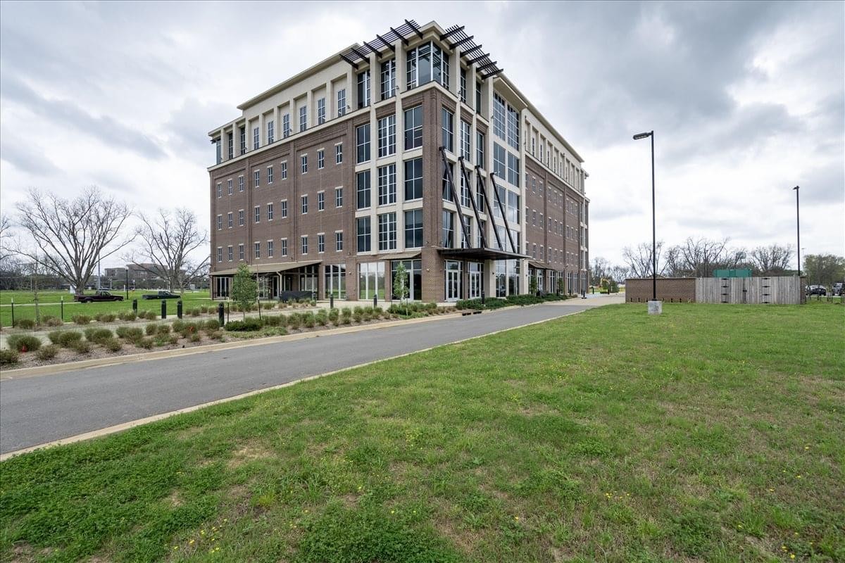 Exterior view of the multi-story brick and glass building at 10000 Century Link Boulevard Suite 200.