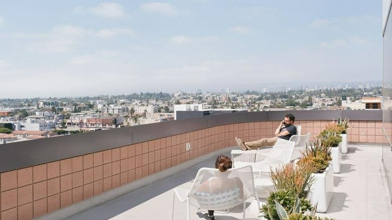 Rooftop terrace with lounge seating and panoramic city views at 10000 Washington Boulevard.