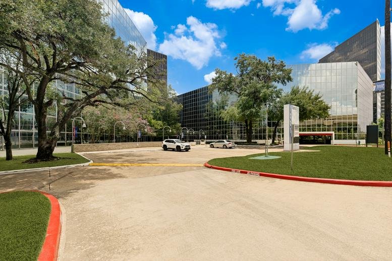 Ground level view of the modern glass building at 1001 West Loop South, Galleria, Houston, Texas.