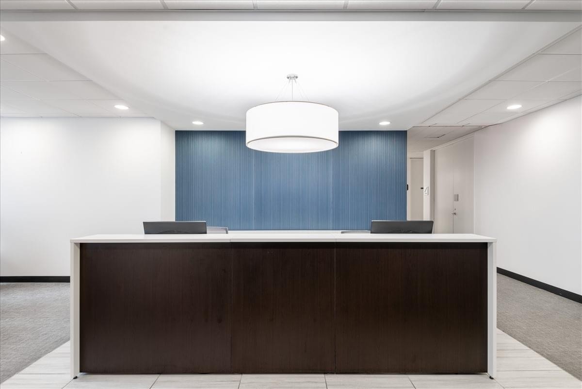 Modern reception desk at 101 Federal Street Center featuring dark wood and a blue backdrop.