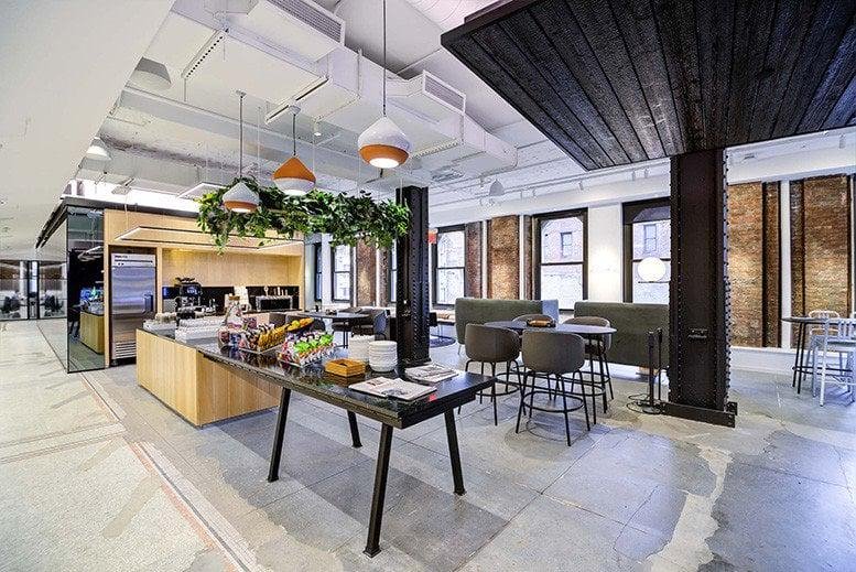 Spacious communal break area at 101 Greenwich St, New York City with a kitchen and greenery.
