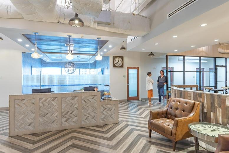 Reception area with a patterned front desk and chevron floors at 101 NE 3rd Ave. Ste. 1500.
