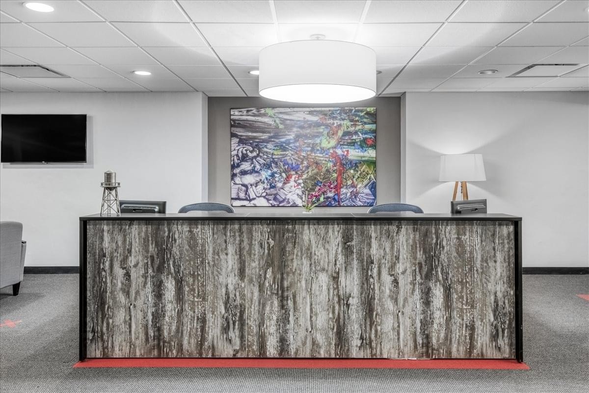 The textured wood-paneled reception desk at 101 Park Avenue, Suite 1300.