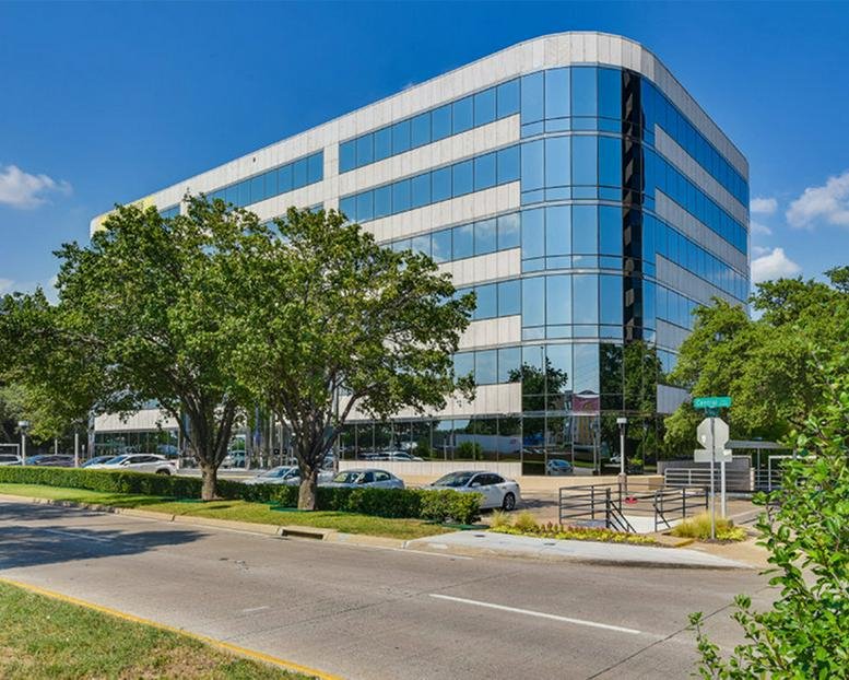 Exterior view of the multi-story glass and stone building at 10100 North Central Expressway.