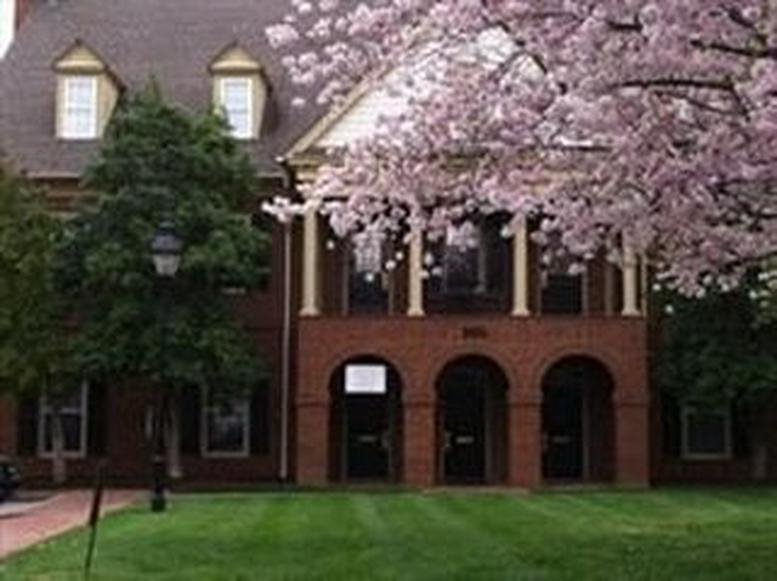 Exterior view of the brick facade at 104 East Park Drive, Building 300 with blooming cherry blossom trees.