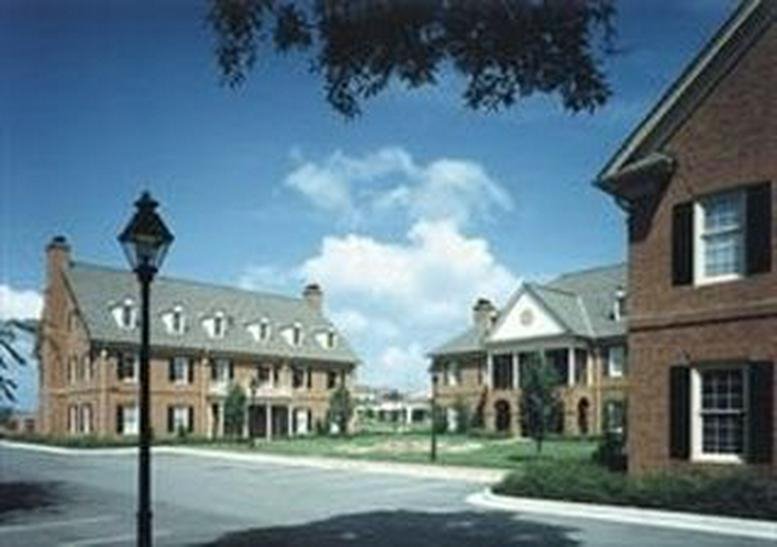 Wide view of several brick office buildings surrounding a central green courtyard.