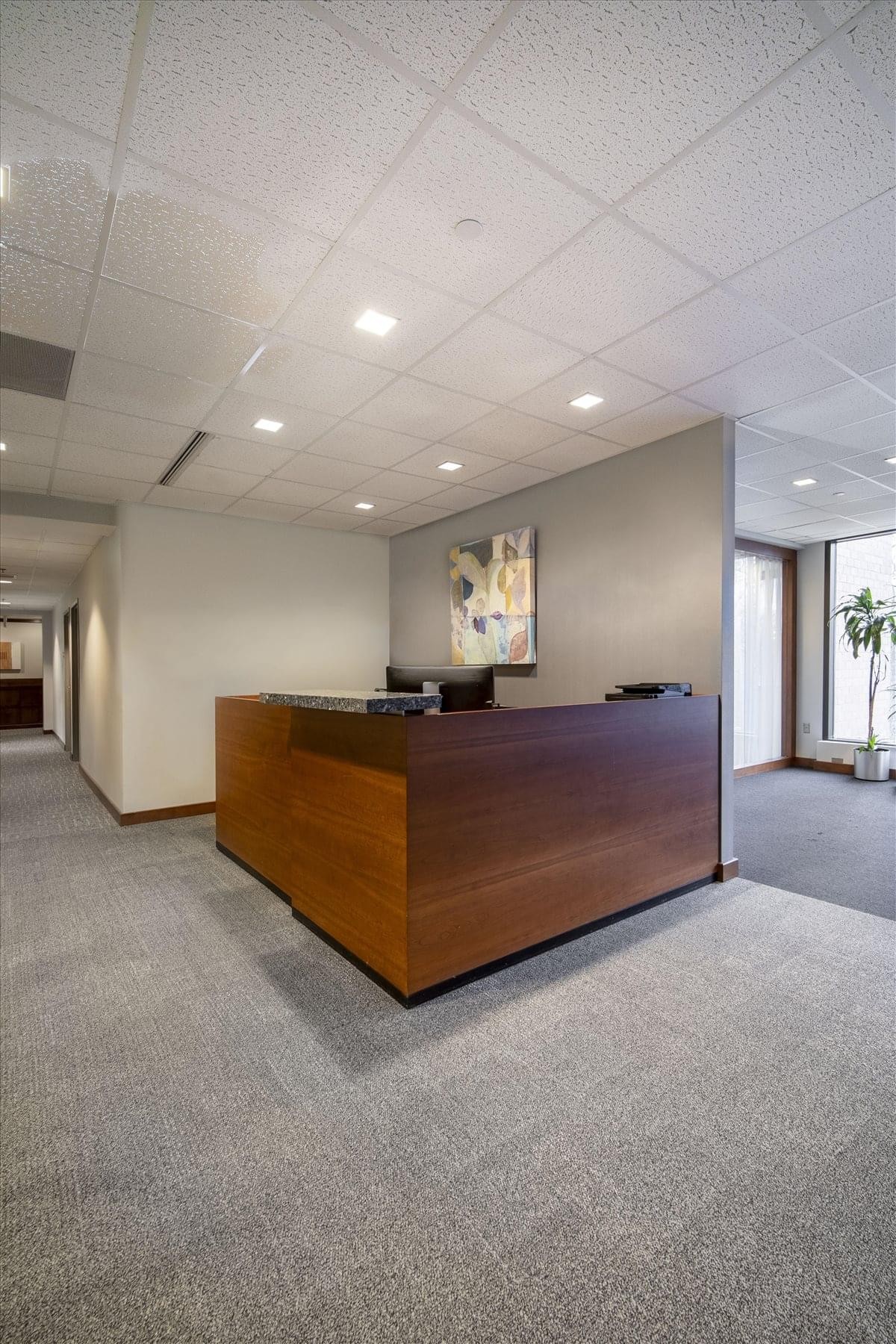 The wood-paneled reception desk under bright LED lighting at 10440 Little Patuxent Parkway, Suite 300.