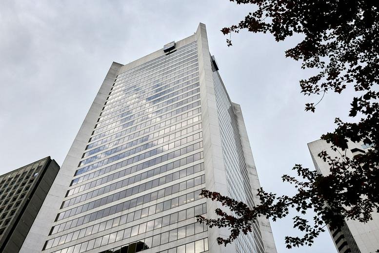 Exterior view of the glass-facade 1055 West Georgia Street building against a cloudy sky.