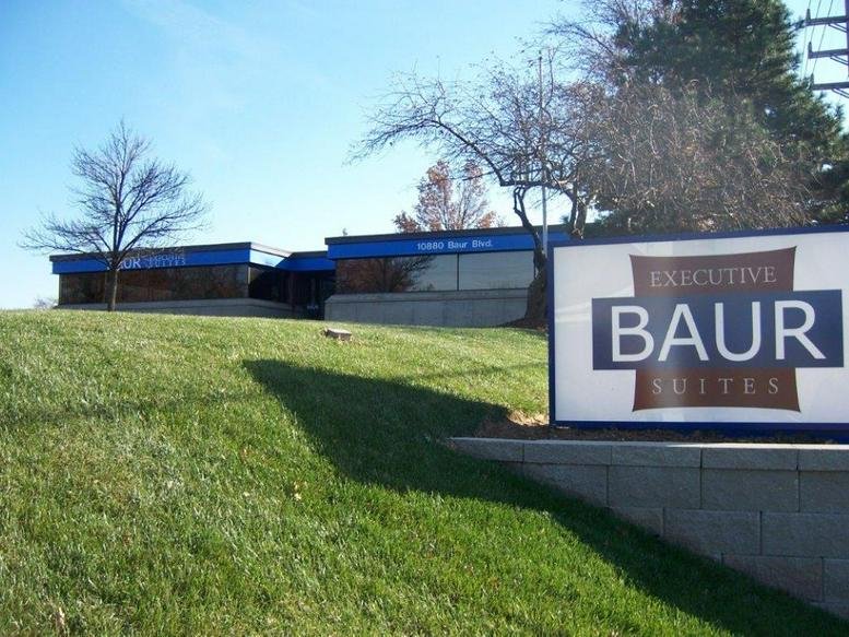 Exterior facade and signage of Baur Executive Suites under a clear blue sky.