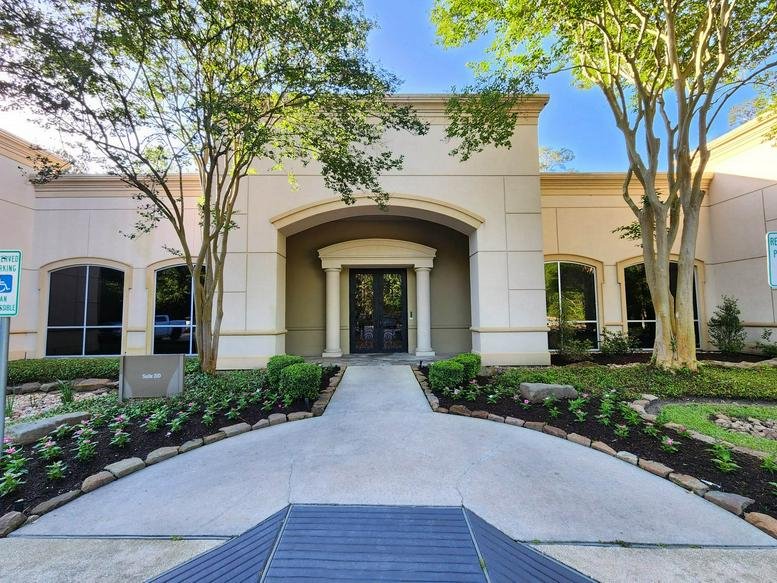 Exterior view of the Mediterranean-style building at 1095 Evergreen Circle, Suite 200, The Woodlands.