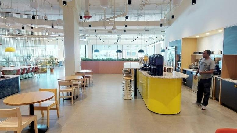 Spacious communal kitchen and cafe area at 110 Corcoran Street, Durham, featuring a bright yellow service counter.