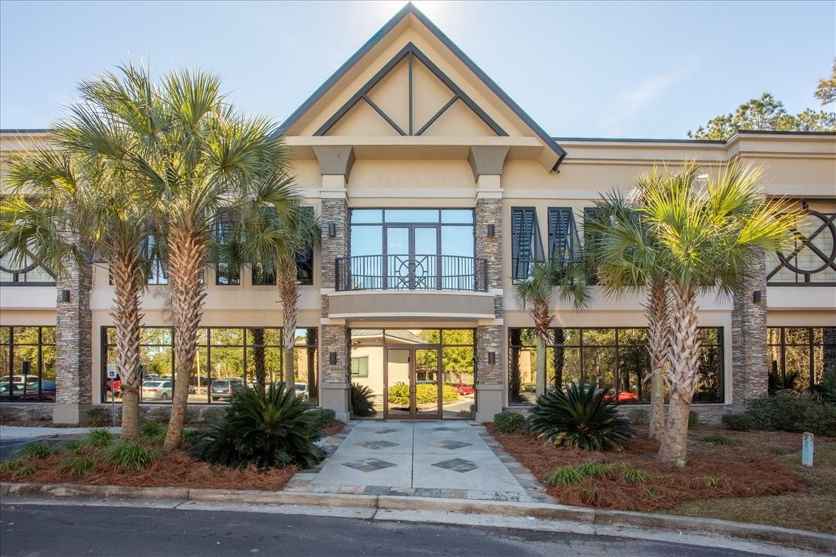 Exterior view of the gabled facade and palm-lined entrance of the Hilton Head Centre.