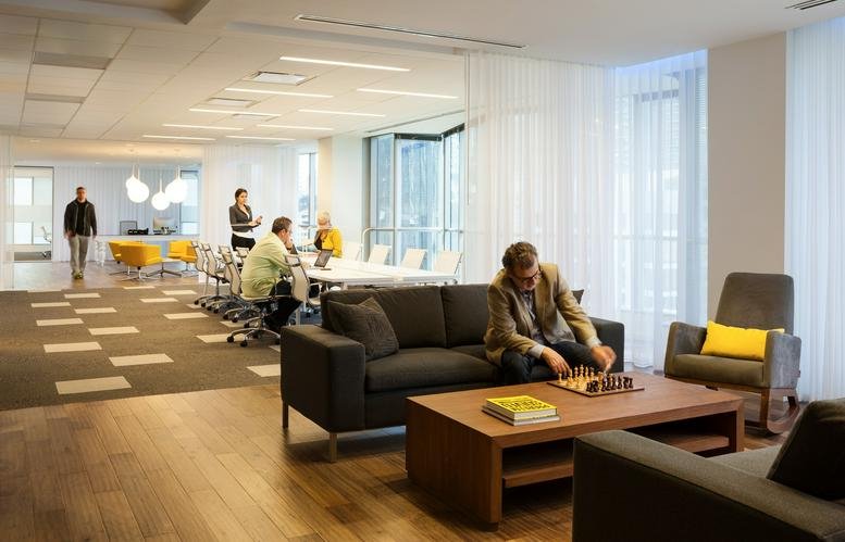 Spacious lounge at 1101 Brickell Avenue, South Tower 8th Floor with wood floors, sofas, and a chess set.