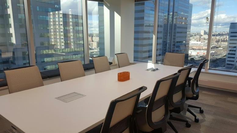 Spacious boardroom with a large white table and panoramic city views at 111 Town Square Pl.