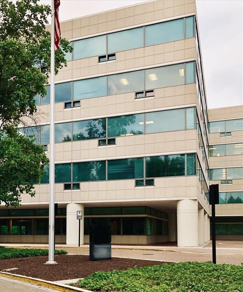 Exterior facade of the 11140 Rockville Pike building with a tall flagpole in front.