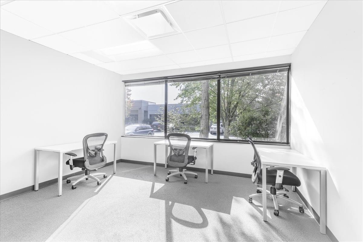 Three-person office suite at 11335 NE 122nd Way, Suite 105 with large windows and natural light.