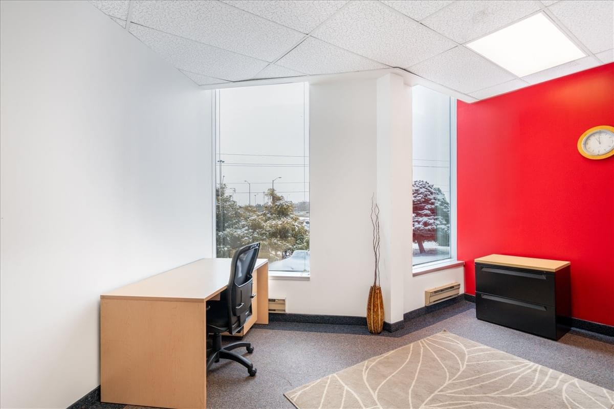 Bright private office at 1155 North Service Road West, Unit 11, featuring a red accent wall and window views.