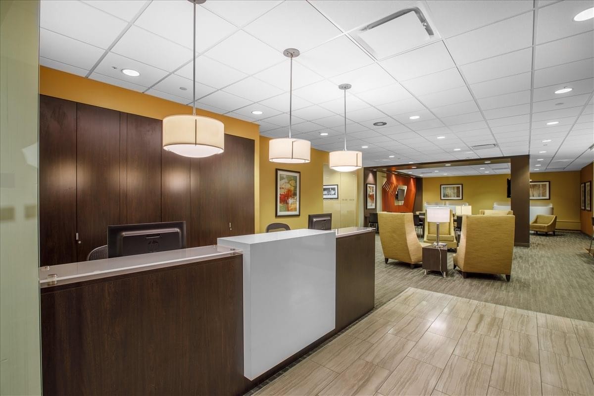 Professional reception area with a dark wood desk and designer pendant lights.