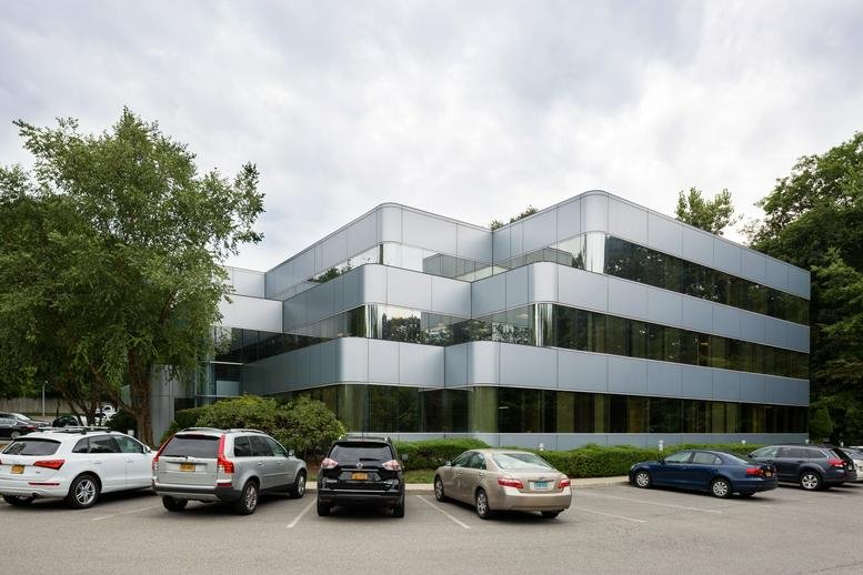 Exterior view of the silver-paneled building at 118 North Bedford Road.
