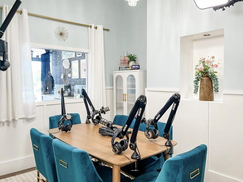 A professional podcasting suite at Wurzbach Studio with teal velvet chairs and overhead lighting.