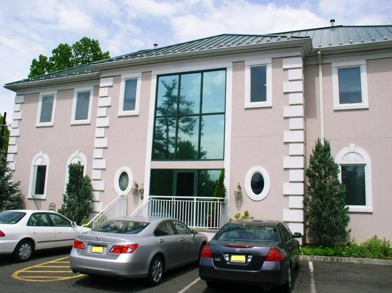 Exterior view of the light pink facade and glass entrance of the 1199 Route 22 East building.