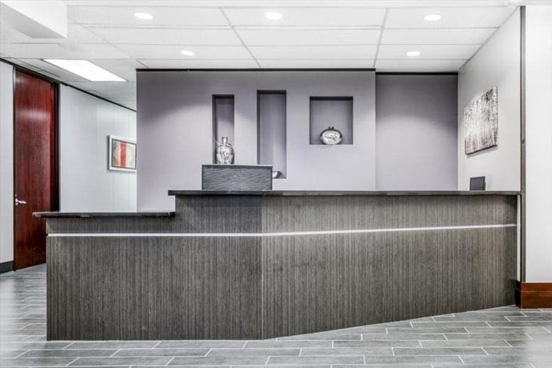 Sleek wood-paneled reception desk with recessed wall niches at 12 Greenway Plaza, Suite 1100.
