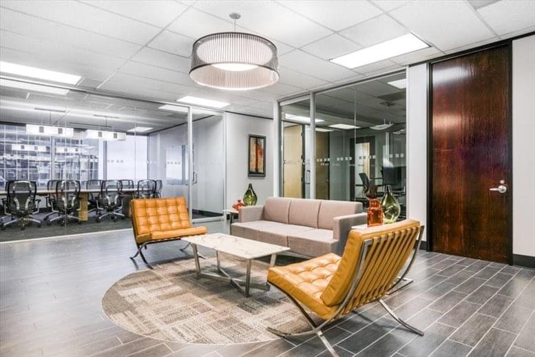 Sleek lounge area at 12 Greenway Plaza with leather chairs and a grey sofa.