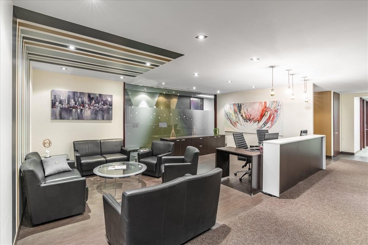 Reception area at 1200 McGill College Avenue, Suite 1100 featuring a wood-slat ceiling and black leather lounge.