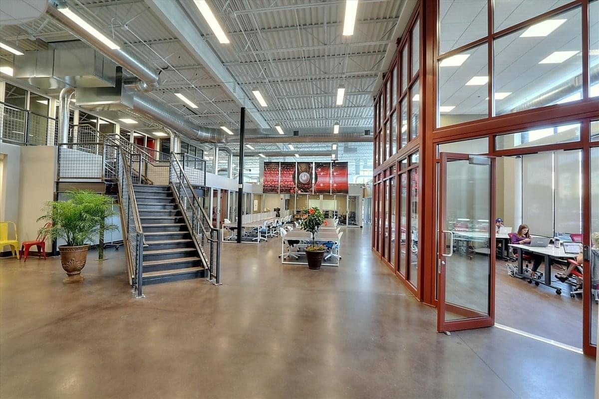 Spacious industrial-style lobby at 12022 Blue Valley Parkway with high ceilings and a central staircase.