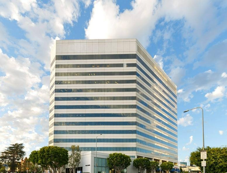 Exterior view of the white multi-story office building at 12121 Wilshire Blvd.