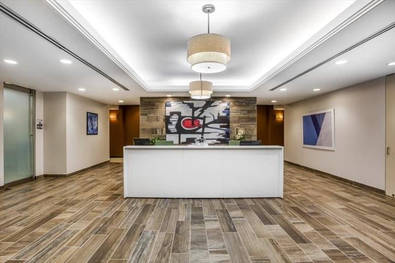 Professional reception area at 125 South Wacker Dr, Suite 300 with a white desk and abstract art.