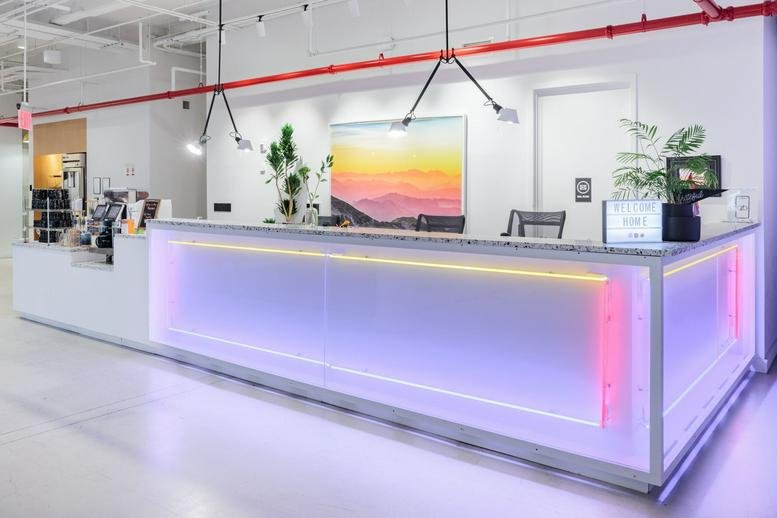 Modern reception desk with neon purple lighting and colorful sunset artwork at 125 West 25th Street.