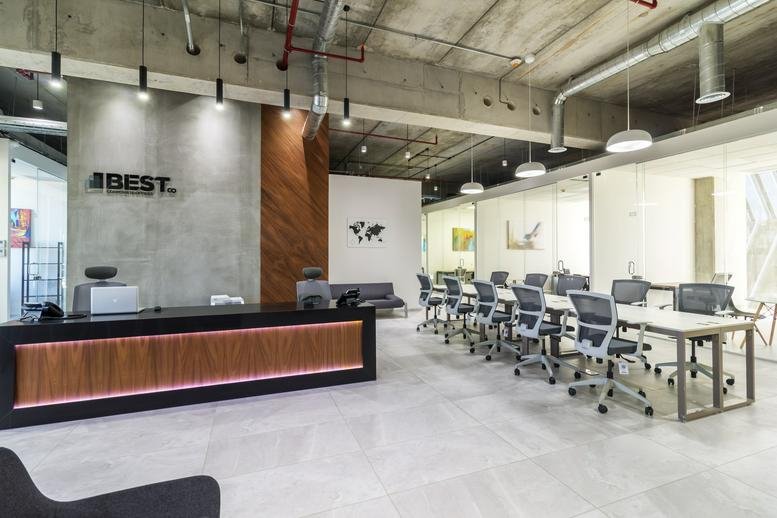 Wide view of a professional reception area and open office layout with world map wall art.