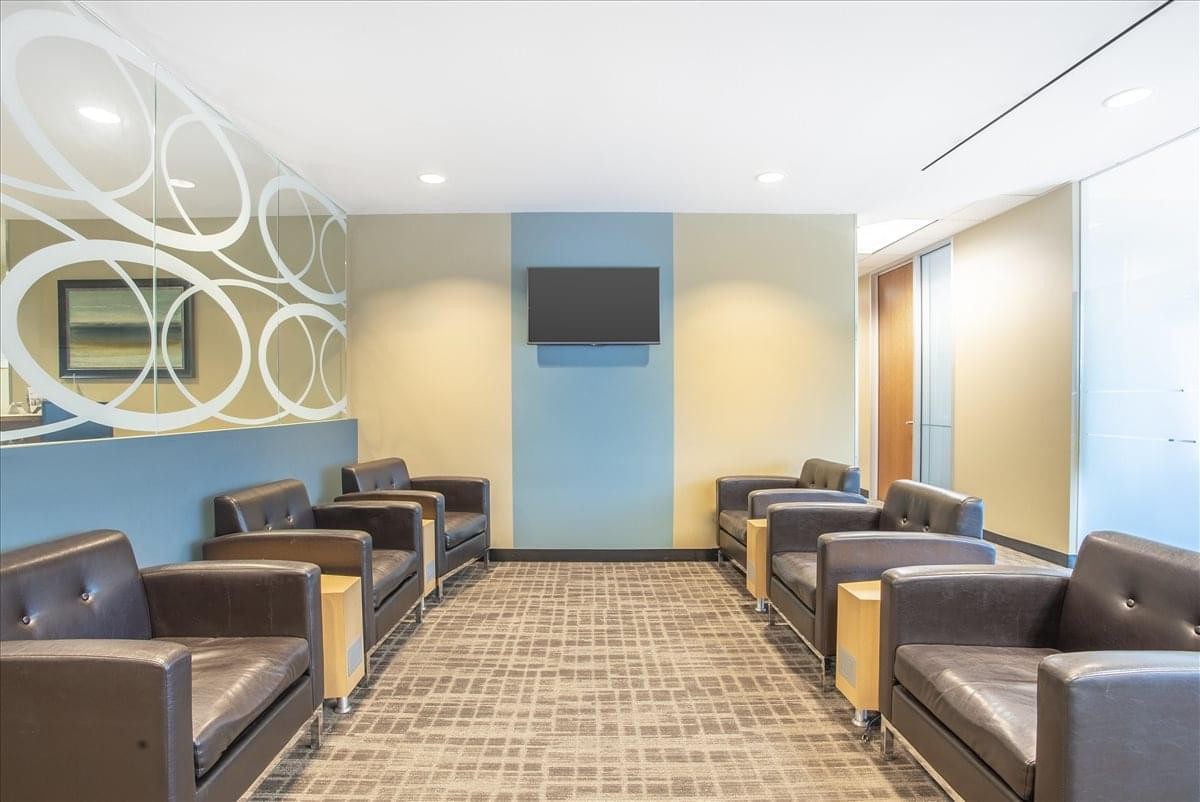 Spacious lounge area with leather armchairs and a blue feature wall at Treat Center.