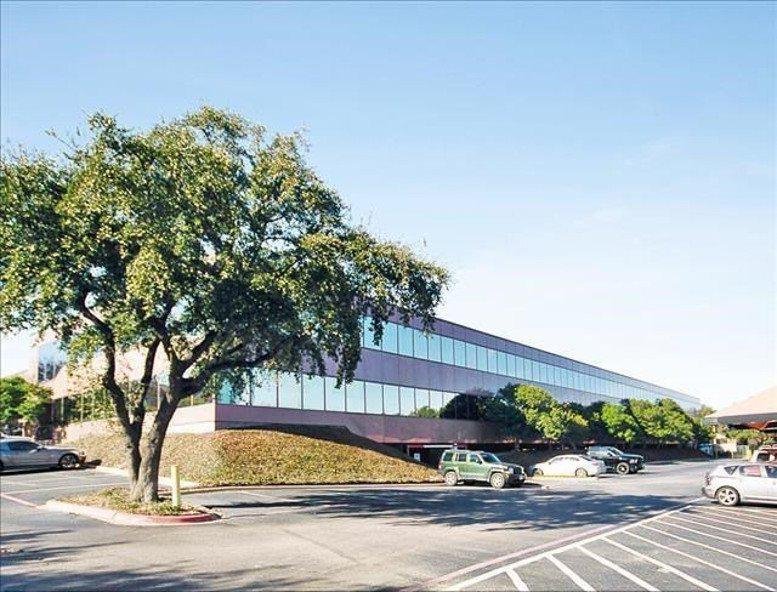 Exterior facade of One Hillcrest at 12700 Hillcrest Road with landscaped lawns and mature trees.