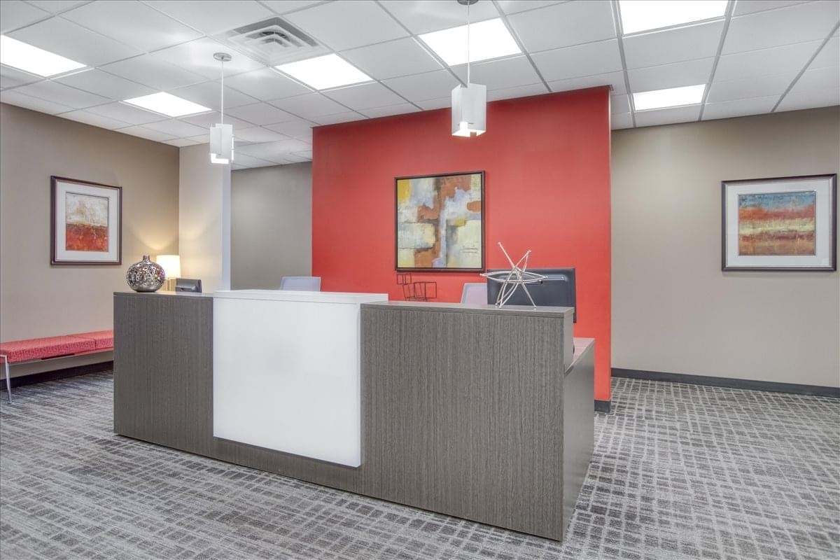 Professional reception desk backed by a vibrant red feature wall.