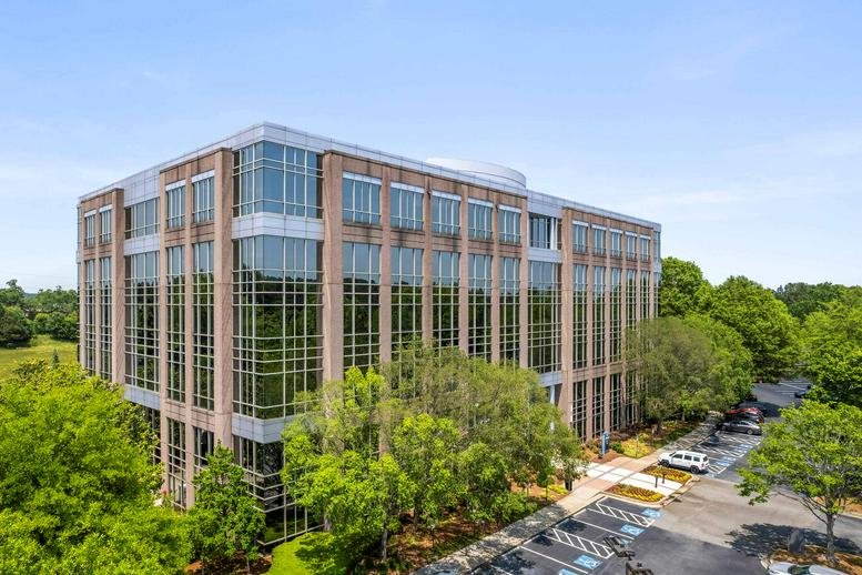 Aerial exterior view of Deerfield Corporate Centre One surrounded by lush green trees.