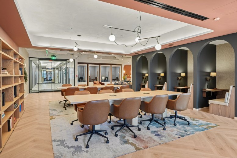 Spacious co-working lounge with arched work nooks and long wooden tables at 131 Dartmouth St, Boston.