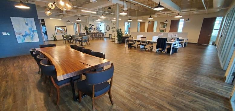 Spacious open-plan common area at 13100 Wortham Center Drive with a large live-edge wood table.