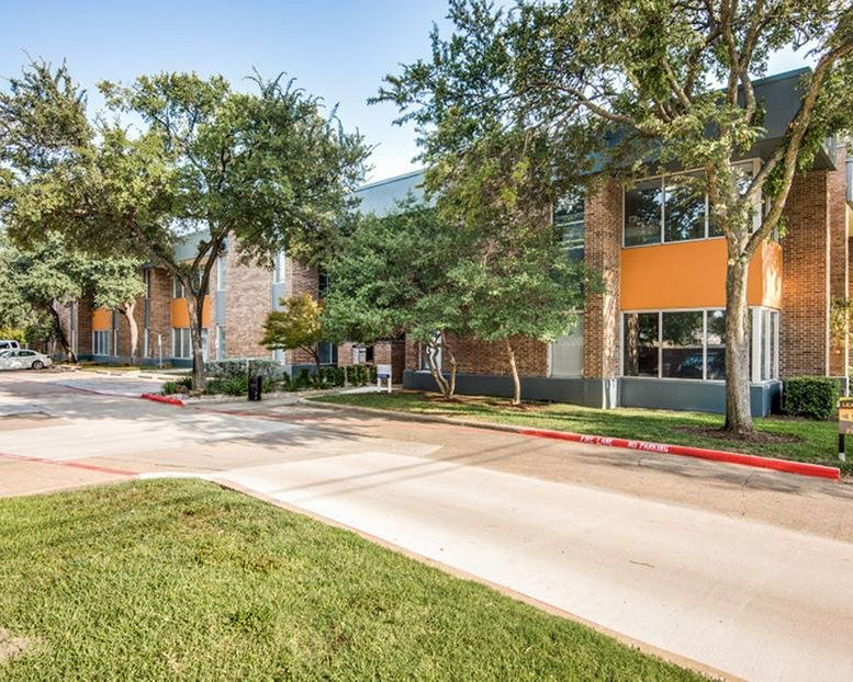 Exterior view of the brick facade and landscaped grounds at 13154 Coit Road, Dallas, Texas.