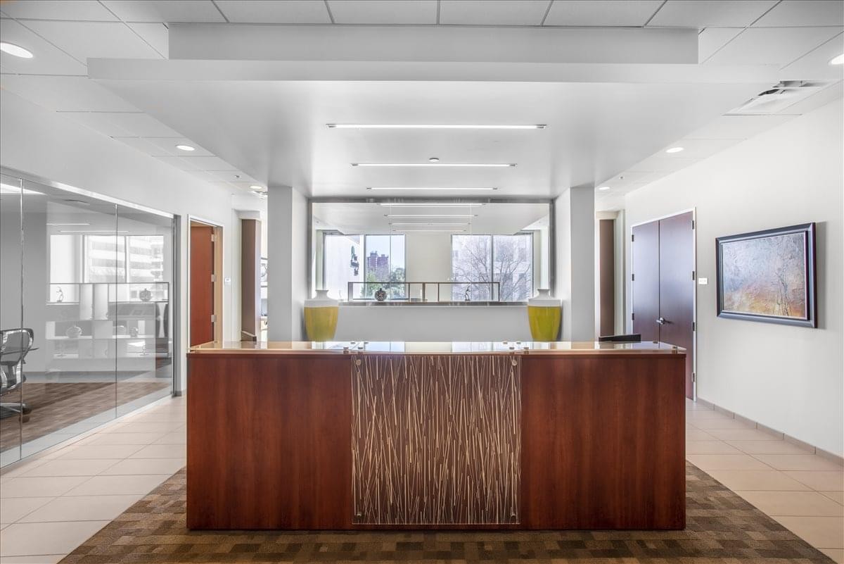 Professional reception desk with wood-paneled front and bright recessed lighting.