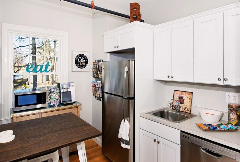 Detail of office signage using letter tiles on a grey wall above wood-framed doors.