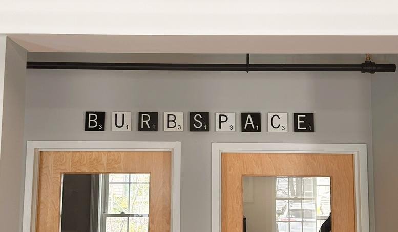 Office signage displaying the name in scrabble-style tiles above wooden doors.