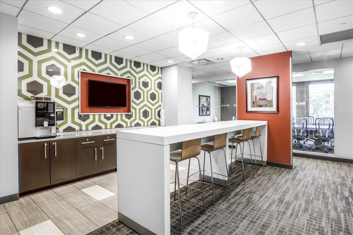 Modern communal breakroom at 1333 Burr Ridge Pkwy with a geometric feature wall and high-top seating.