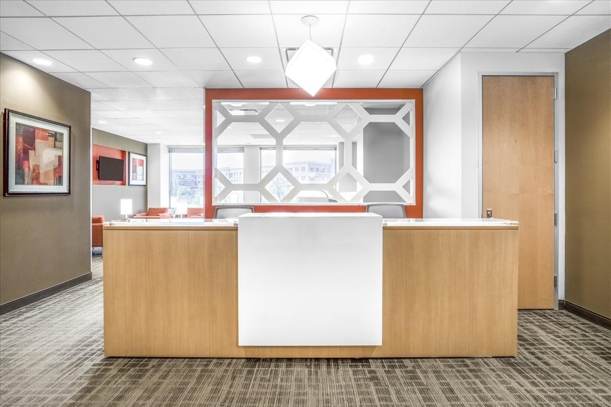 Professional reception desk at 1333 Burr Ridge Pkwy, Suite 200, Village Centre with geometric backdrop.