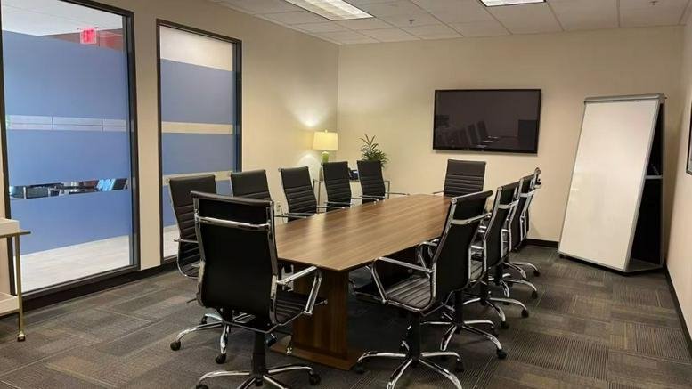 Modern meeting space with high-back black chairs and a mobile whiteboard.