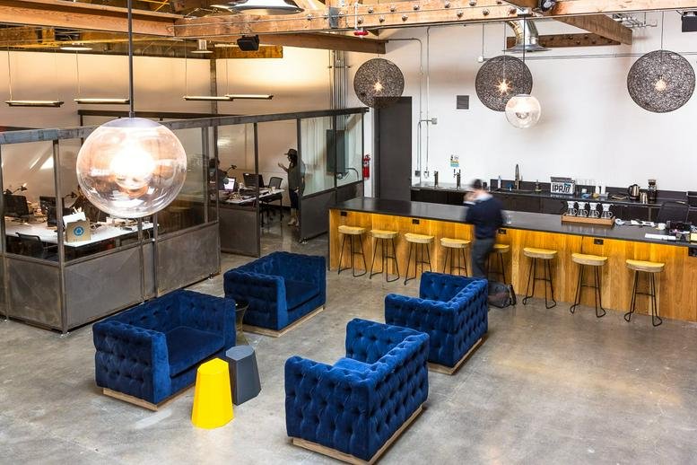 Spacious communal lounge at 1355 NW Everett, Portland (Oregon) with blue velvet sofas and a bar area.