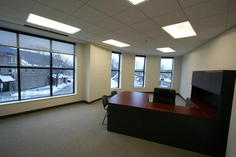 Spacious private corner office at 1363 Shermer Road with a large wrap-around desk and snow-covered street views.